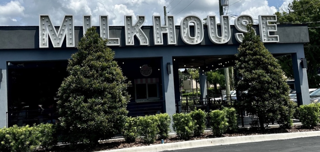 large white metal letters on top of a restaurant say milk house