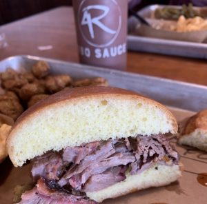 half of a brisket sandwich full of meat