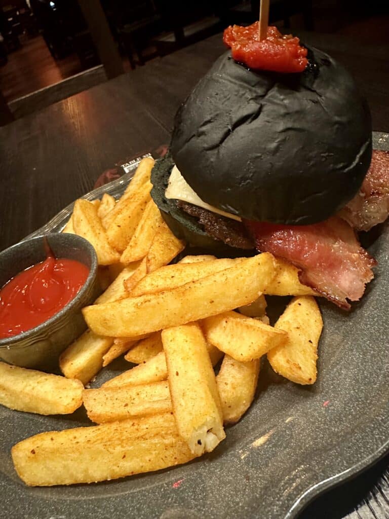 hamburger on a black bun at das steakhouse epic universe